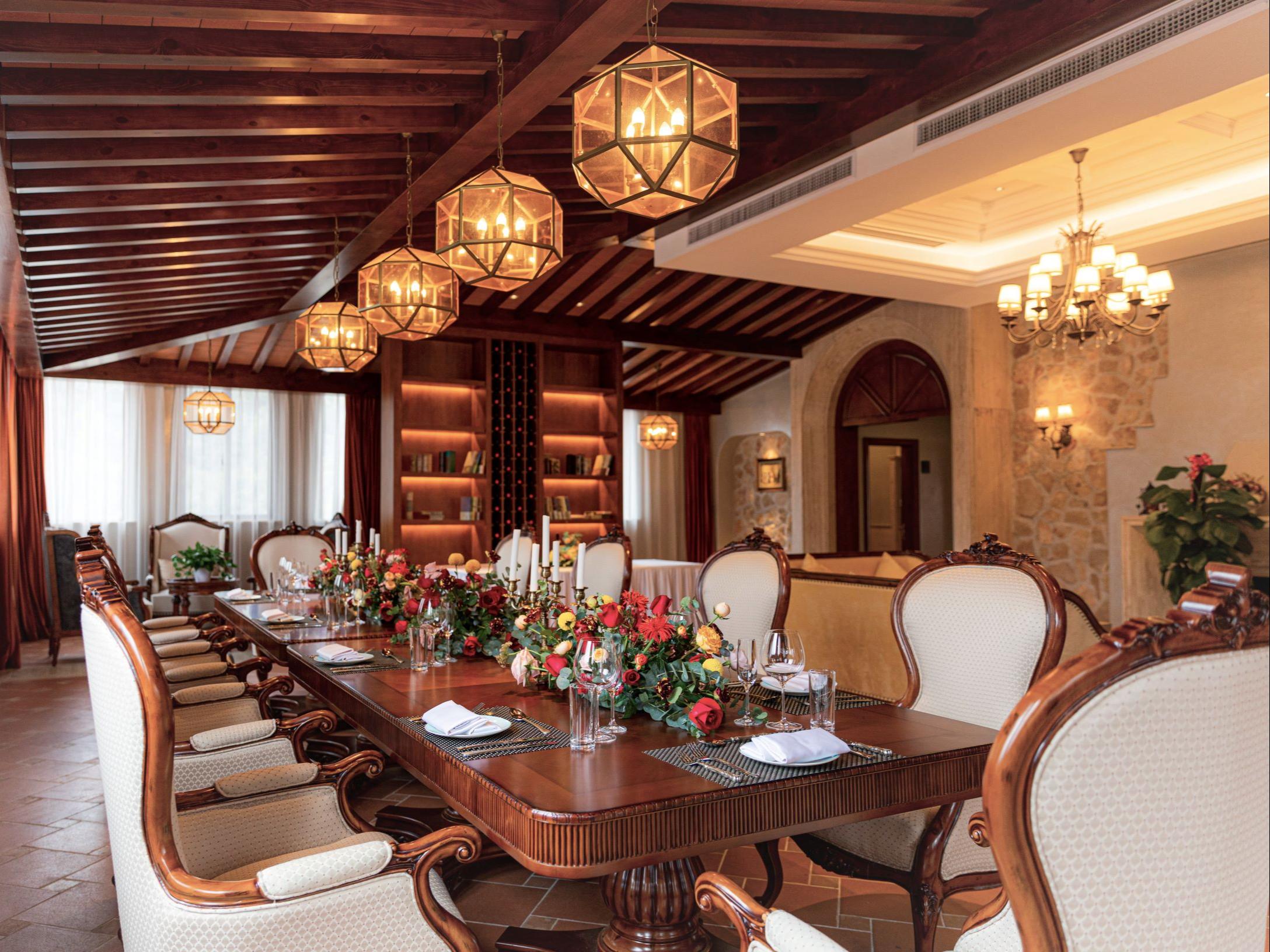 Large dining room with chandeliers and antique table and chairs set up for a wedding